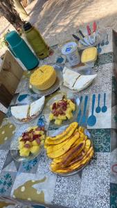 a table with plates of bananas and fruit on it at Suíte Beija-flor in Camaçari +19 photos