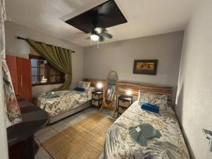 a room with two beds and a desk with a mirror at Boomhuisie in Komatipoort