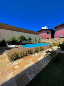 a swimming pool in a yard next to a building at Flat Casa da Praia in Porto De Galinhas