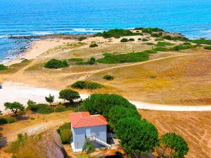 a small house on a beach next to the ocean at Romanos Beach Villas in Romanu