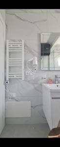 a white kitchen with a sink and a counter at Abla's sweet home in Tirana +31 photos
