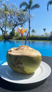a vase with a flower in it sitting on a plate at Villa Saffraan Bali in Banjar