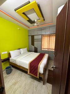 a bedroom with a bed with green walls at Ps5HOMESTAY in Tirupati