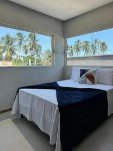 a bedroom with a large bed with a large window at Casa a 1200m da Praia do Patacho - Casa Garaguá in Pôrto de Pedras