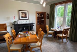 a dining room with a table and chairs and a fireplace at Burnbank Bed and Breakfast in Moffat