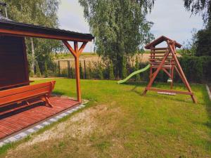 a playground with a bench and a slide at Domki Przydwórz in Przydwórz