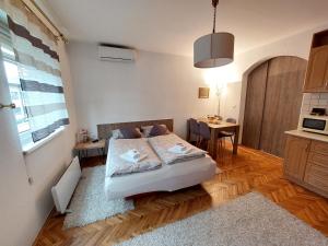 Un dormitorio con una cama y una mesa y una cocina. en MB Deluxe Apartment, en Visoko