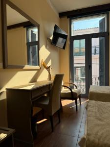 a living room with a desk and a mirror at Alley Rooms in Mytilene