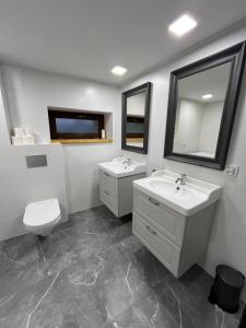 un bagno con due lavandini, un water e uno specchio di Dom Podgórze 23 a Duszniki Zdrój Altre 101 foto
