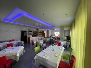 a restaurant with white tables and chairs and blue lights at Papavero Giallo B&B in Le Castella