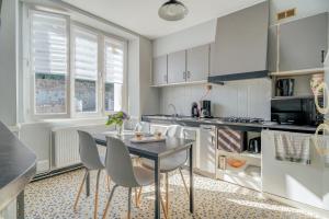 Una cocina con una mesa y sillas en una habitación. en Maison Chaleureuse Cancale, en Cancale