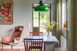 a dining room with a table and chairs and a green lamp at Gästhus Centralt i Småland in Fiskesjö