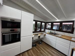 a kitchen with white cabinets and a table with chairs at Very nice flat in Lerici 5 terre Villa Aurora in centro con parcheggio in Lerici