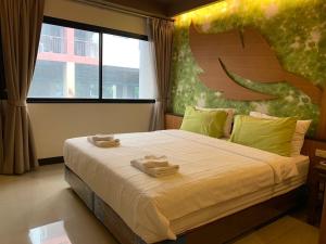 Ban Na SongにあるLe Ram Hotel No windowsの大きなベッドとタオル2枚のある寝室