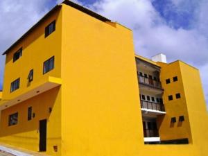 un edificio amarillo con un cielo en el fondo en Pousada das Estrelas, en São Thomé das Letras
