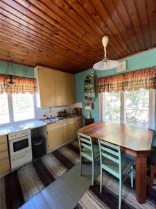 eine Küche mit Holzdecke, Holztisch und Stühlen in der Unterkunft Soludden in Raseborg + 12 Fotos