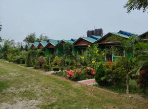 a row of houses with flowers and plants at Sudarshan Resort in Haraincha