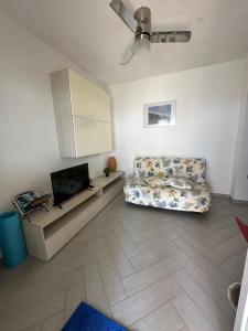 a living room with a couch and a flat screen tv at La casa del Tramonto in Praia a Mare
