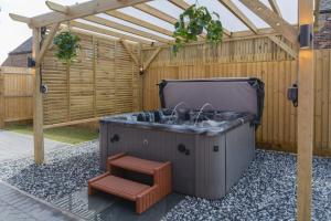 a hot tub in a backyard with a pergola at The Orchard in Telford +79 photos