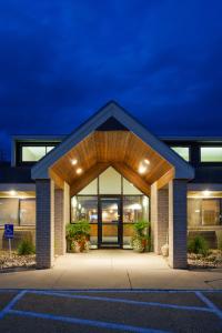 a building with a entrance with lights on at AmericInn by Wyndham Clear Lake in Clear Lake