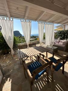 a patio with a table and chairs and a couch at La casa del Tramonto in Praia a Mare