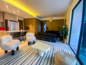 een woonkamer met een bank, stoelen en een tafel bij GTC Residence in Nairobi