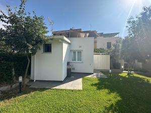 a white house with a green lawn in front of it at Villa Oasi Verde in Cinisi +23 photos