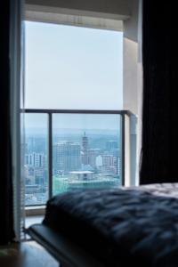 een slaapkamer met een groot raam met uitzicht op de stad bij GTC Residence in Nairobi