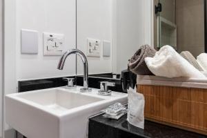a bathroom with a sink and a mirror and towels at LO 503 Studio Moderno e Confortável no melhor da Vila Mariana ! in Sao Paulo +30 photos