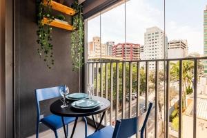 a balcony with a table and chairs and a view of the city at LO 503 Studio Moderno e Confortável no melhor da Vila Mariana ! in Sao Paulo