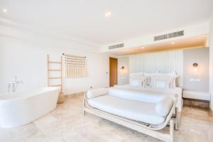 Un dormitorio blanco con una cama grande y una bañera. en Increíble dpto de lujo con acceso a club de playa, en Cancún 54 fotos más