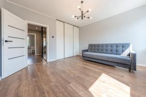 una sala de estar vacía con un sofá azul y una puerta en Grand Solen Apartment, en Gdansk