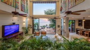 a living room with a flat screen tv and large windows at Villa Divina Luxury Boutique - Adults Only in Puerto Vallarta