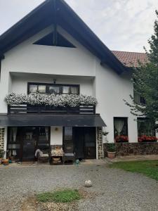 a white house with a balcony with flowers on it at Casa Stana de Vale in Sovata