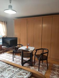 a living room with a table and chairs and a tv at Casa Stana de Vale in Sovata