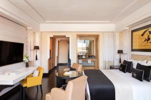 a hotel room with a king sized bed and a living room at H&ocirc;tel & Ryads Barri&egrave;re Le Naoura in Marrakech