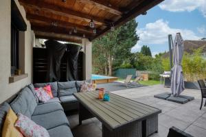 a patio with a couch and a wooden table at Jolie Villa, 300 m2, grand jardin in Furdenheim