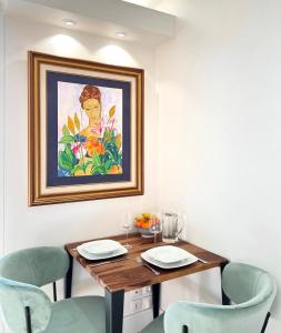 a dining room table with chairs and a painting on the wall at Kantaldi in Guéthary