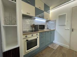 a kitchen with blue cabinets and a microwave at Kantaldi in Guéthary