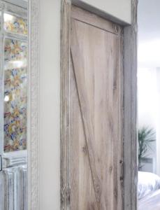 a wooden door in a bedroom with a mirror at Kantaldi in Guéthary