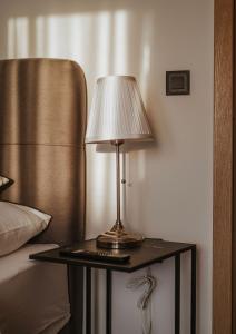a lamp on a table next to a bed at Apartman VI u centru Kutine in Kutina