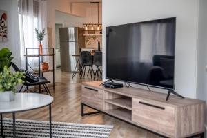 ein Wohnzimmer mit einem großen Fernseher auf einem hölzernen Entertainment-Möbel in der Unterkunft Le Professionnel in Campbellton