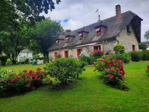 a house with flowers in front of it at Chambre d hôte les bosquets in Caugé