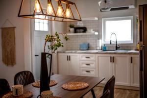 eine Küche mit einem Holztisch mit Stühlen und einer Deckenleuchte in der Unterkunft Le Professionnel in Campbellton