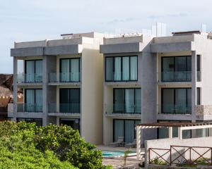 Un edificio de apartamentos con balcones y árboles. en Yaxche by Andiani Travel, en Isla Mujeres