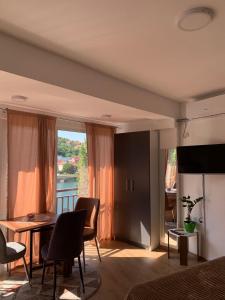 a living room with a table and chairs and a large window at Aluna 4 in Višegrad +6 photos
