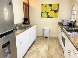 坎昆Habitación dentro de un departamento muy bien ubicado的厨房配有白色橱柜、水槽和炉灶 更多3张照片