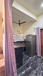 a kitchen with a refrigerator and purple curtains at Himaksh Homestay in Varanasi