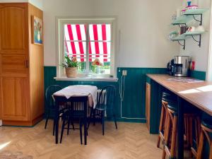 a kitchen with a table with chairs and a window at Bubo mysigt litet hus i Noret in Mora