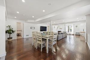 Un comedor y una sala de estar con mesa y sillas. en The Nautical Nook Luxury Beach House, en Hamilton